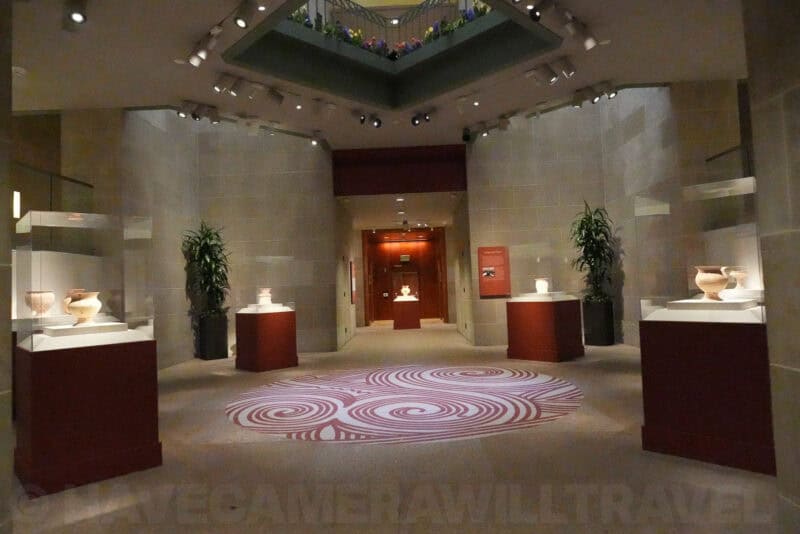 Museum gallery interior with ceramic vases and red pedestals, ISO 32000 grain test