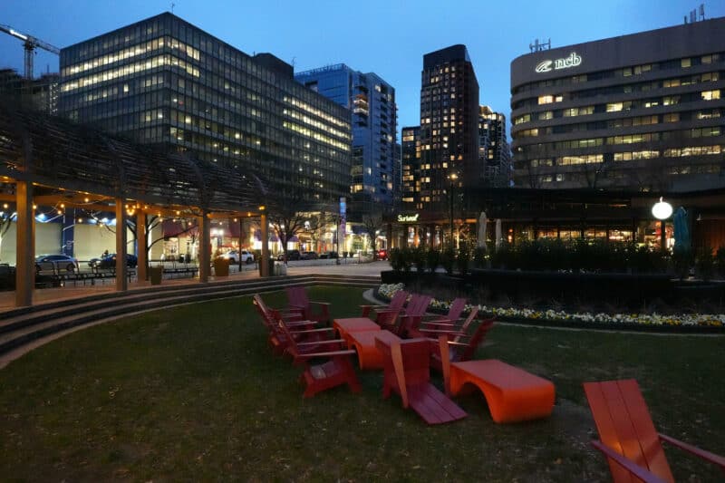 Urban park at night with red chairs on grass and glowing towers, ISO 16000 sample
