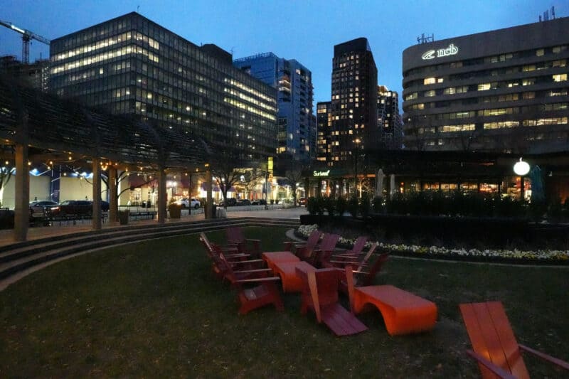 Dim city courtyard with red chairs and building lights, ISO 40000 noise test image