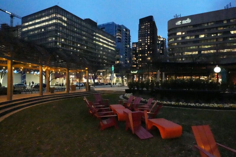 Low-light urban scene with red chairs and glowing skyline, ISO 51200 grain sample