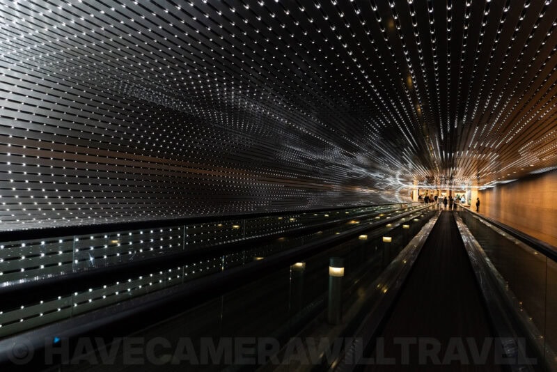 Illuminated tunnel walkway with dense sparkling lights stretching into the distance