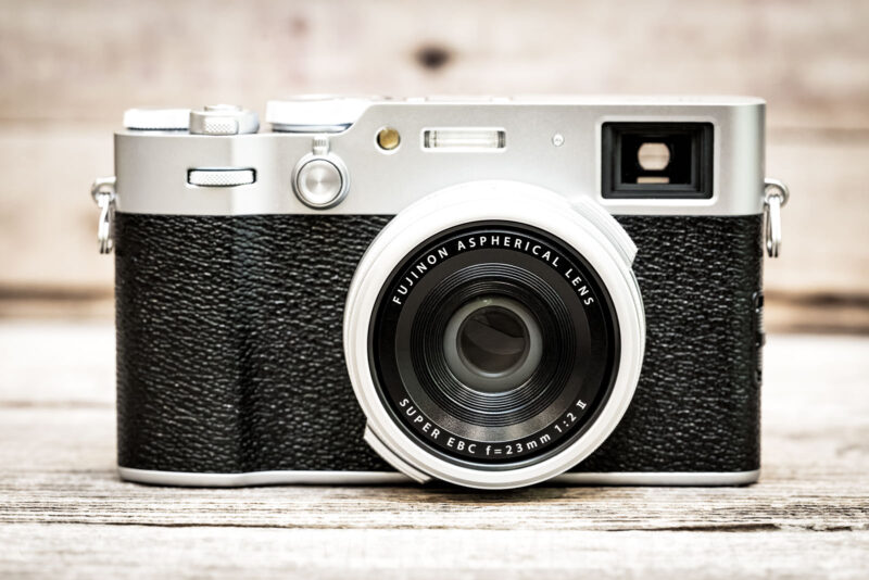 Fujifilm X100VI front view showing the silver top plate, viewfinder, and Fujinon 23mm lens