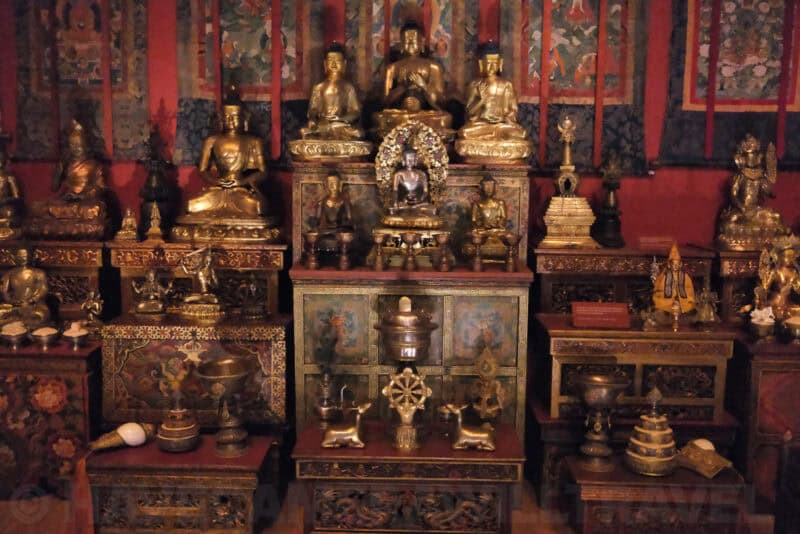 Gilded Buddhist statues and shrine display in a museum exhibit at extended ISO 51200 with the noisiest, softest detail