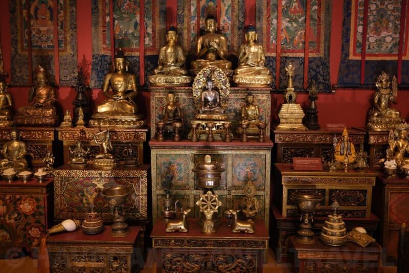Gilded Buddhist statues and shrine display in a museum exhibit at ISO 125 with slight softness