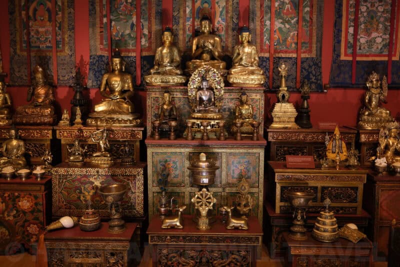 Gilded Buddhist statues and shrine display in a museum exhibit at ISO 200 with clean shadows