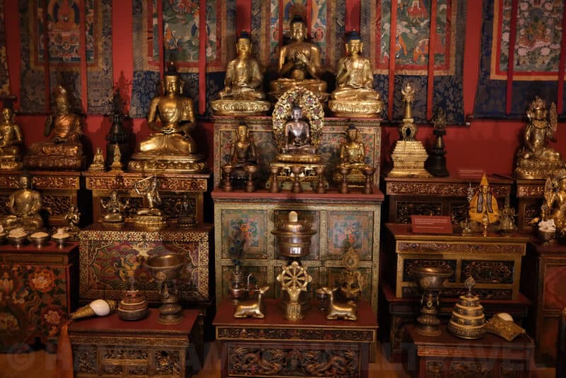 Gilded Buddhist statues and shrine display in a museum exhibit at ISO 4000 showing coarser texture