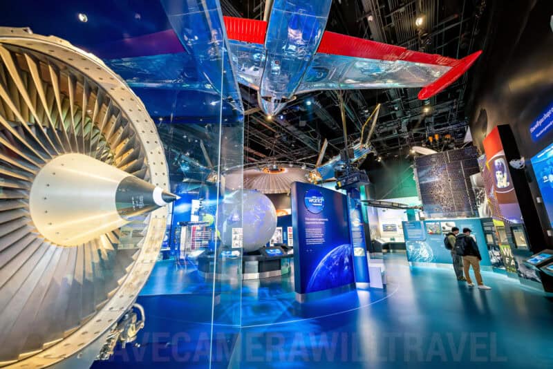 Jet engine cutaway and satellite exhibits in a space and technology museum display