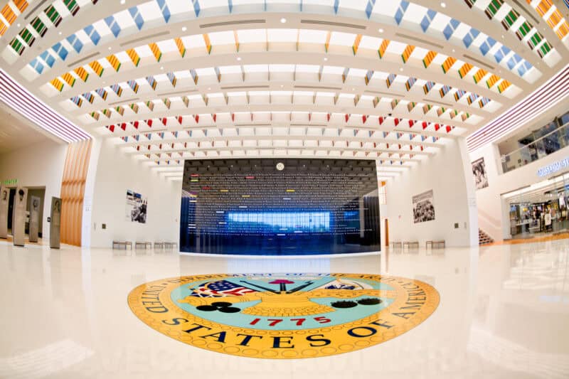 Fisheye view of a museum atrium with a large national seal medallion inlaid in the floor
