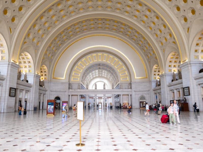 Grand vaulted hall of Union Station with travelers crossing the marble floor