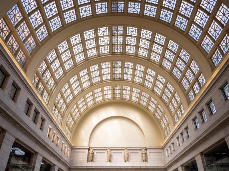 Vaulted glass skylight ceiling above classical statues inside Union Station