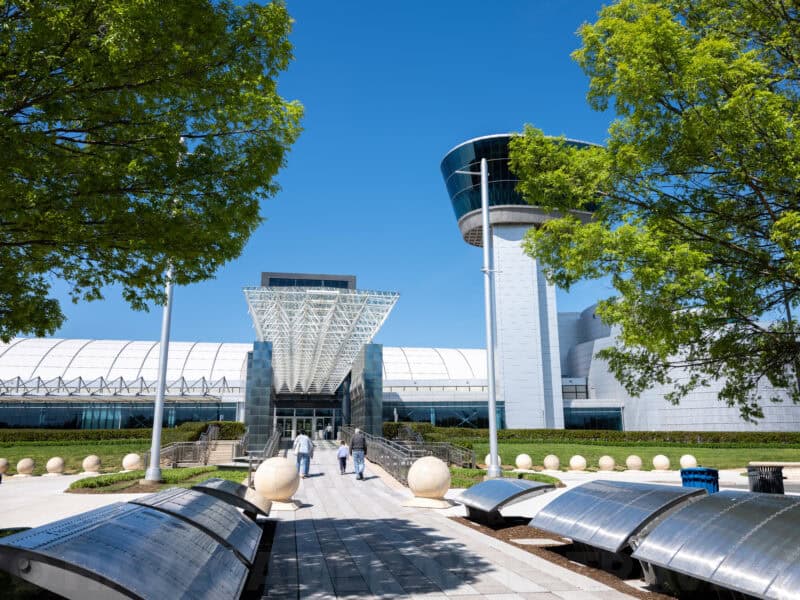 Tree-lined walkway leading to the Udvar-Hazy Center's glass entrance and control tower