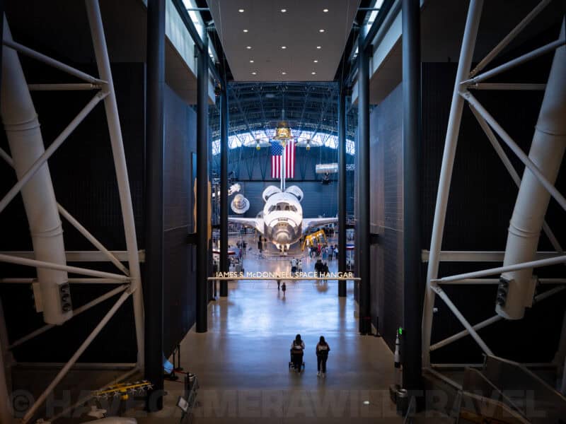 Space shuttle displayed nose-on inside the James S. McDonnell Space Hangar with visitors below