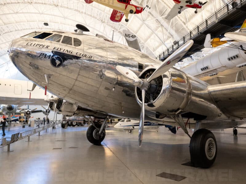 Polished silver Clipper Flying Cloud airliner displayed inside an aviation museum hangar