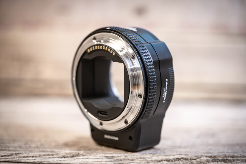 MonsterAdapter LA-FZ1 at a three-quarter angle, showing its mount contacts, knurled ring, motor bulge and side lettering
