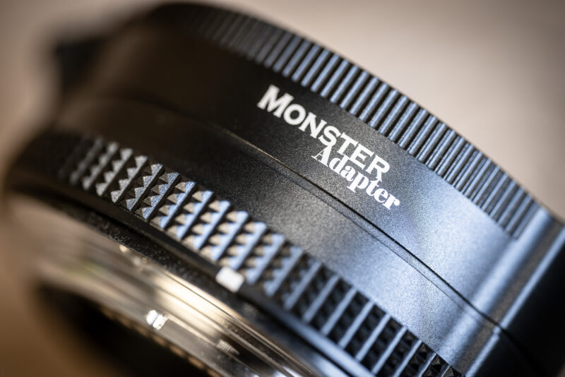 Close-up of the MonsterAdapter LA-FZ1 lens adapter's black ring, with white MonsterAdapter logo and diamond-knurled grip