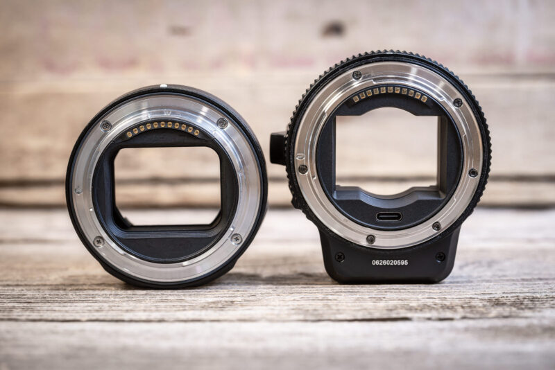 Nikon FTZ II beside the larger MonsterAdapter LA-FZ1, both mount rings facing the camera on a weathered wooden surface