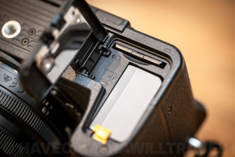 Nikon Z50 II open compartment door showing the memory card slot and battery side by side